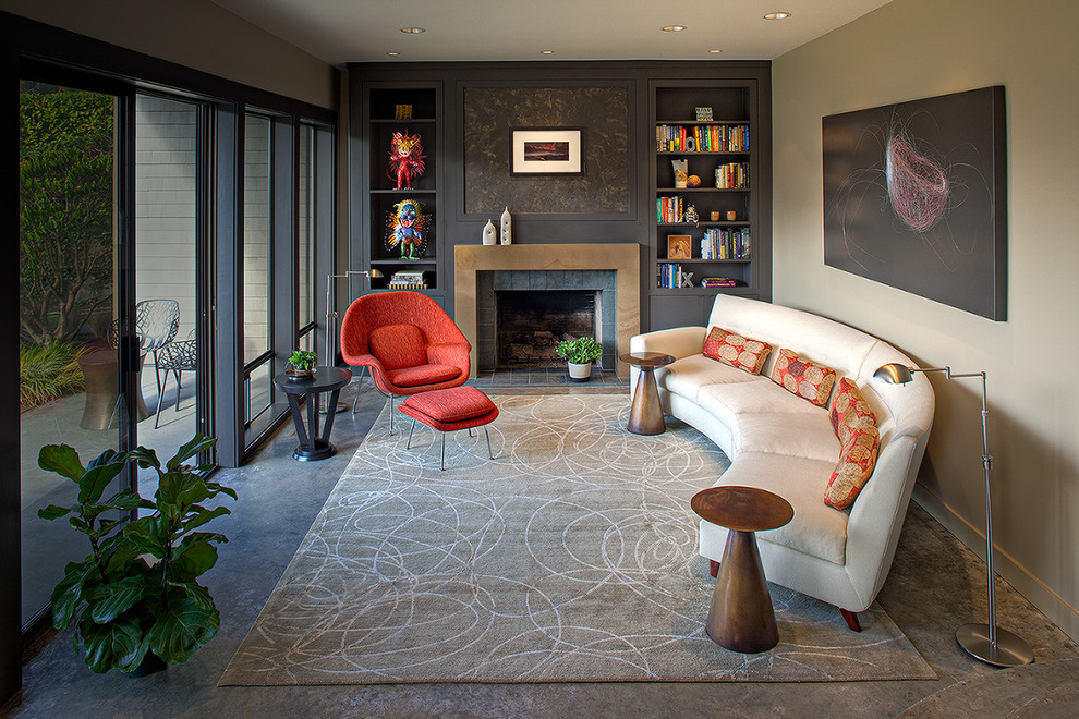 Свежая идея для дизайна: изолированная, парадная гостиная комната в современном стиле с бетонным полом, серыми стенами, стандартным камином, фасадом камина из плитки и ковром на полу без телевизора - отличное фото интерьера