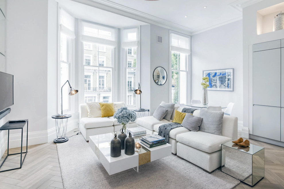 Example of a mid-sized trendy open concept light wood floor and beige floor living room design in London with white walls, a wall-mounted tv, a two-sided fireplace and a stone fireplace