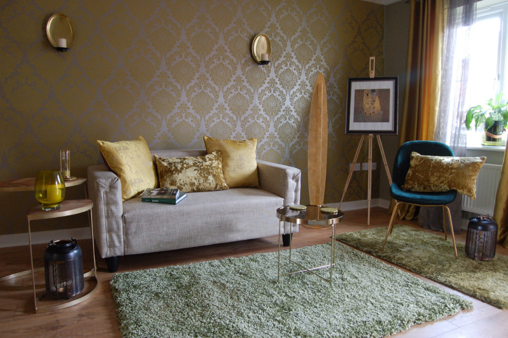 Modelo de salón cerrado bohemio de tamaño medio sin chimenea y televisor con paredes verdes, suelo laminado, suelo marrón y papel pintado