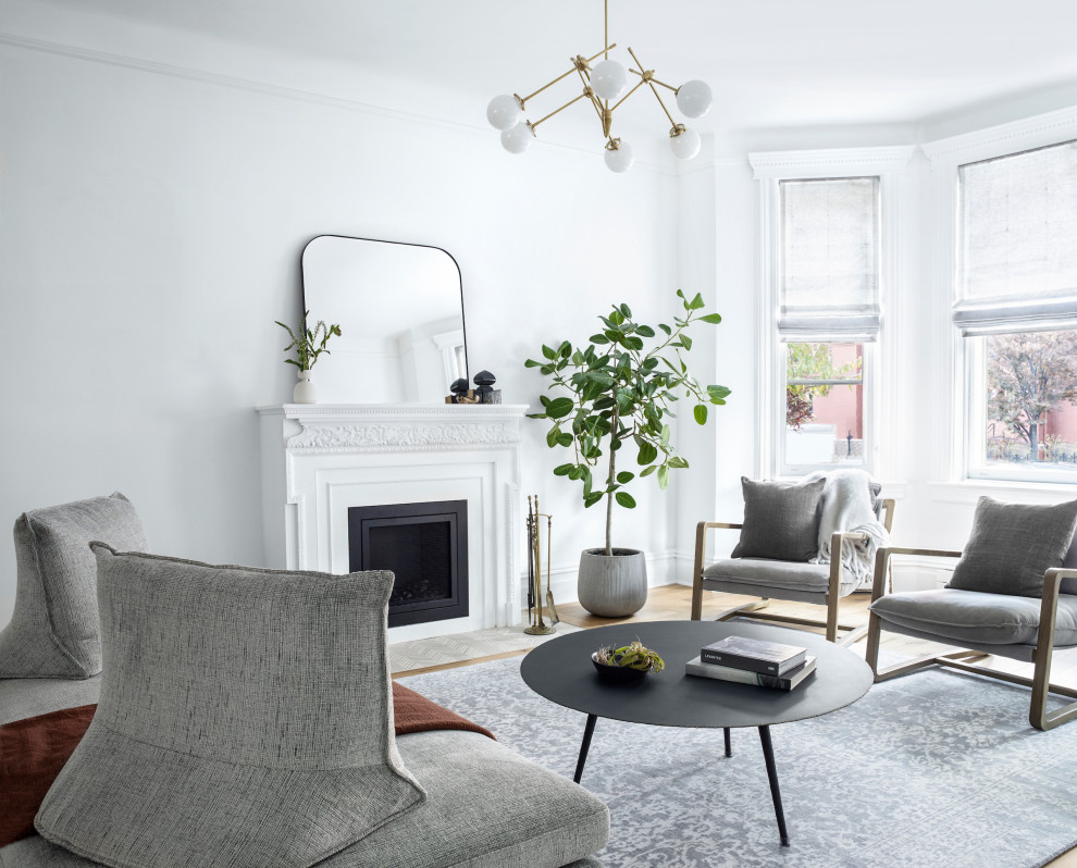 Repräsentatives, Fernseherloses, Abgetrenntes Klassisches Wohnzimmer mit weißer Wandfarbe, braunem Holzboden, Kamin und braunem Boden in New York