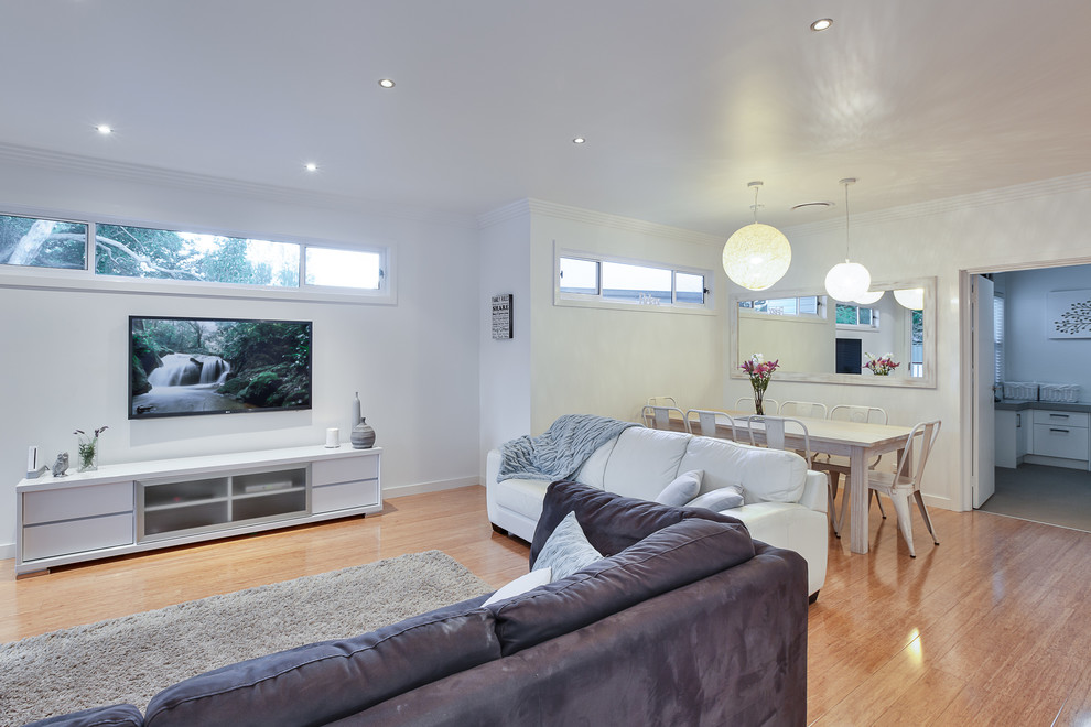 Offenes, Mittelgroßes Modernes Wohnzimmer mit weißer Wandfarbe, hellem Holzboden und TV-Wand in Sydney