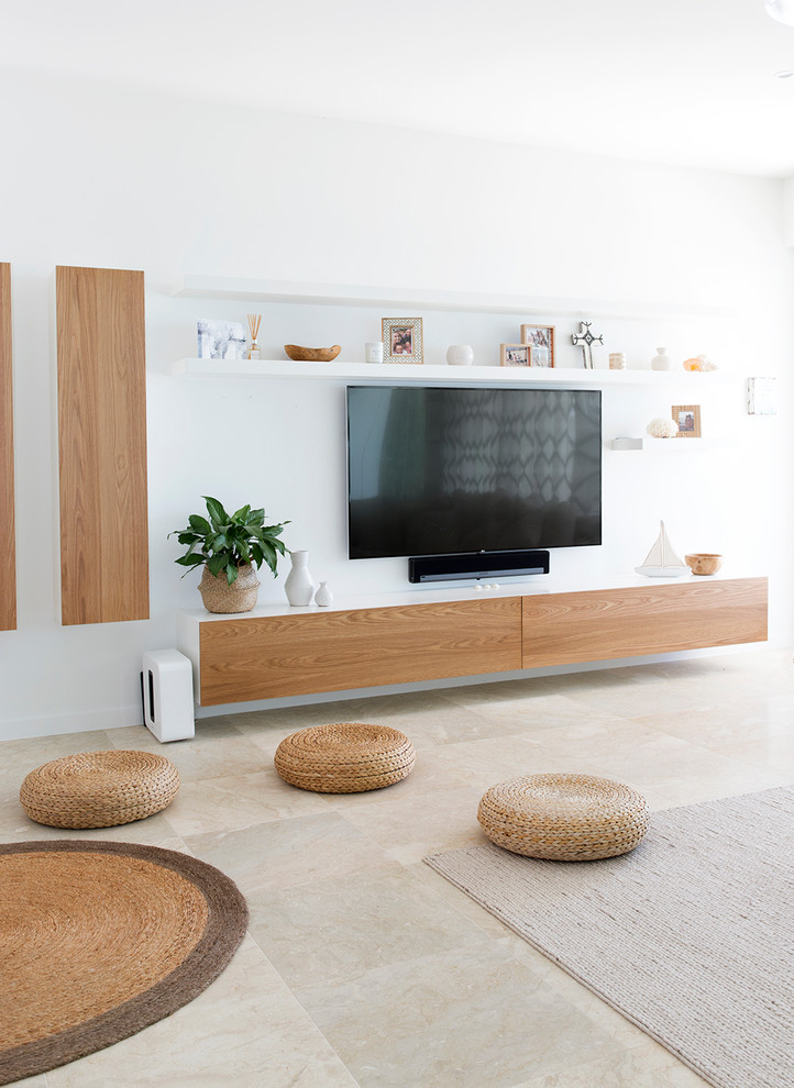 Esempio di un grande soggiorno design aperto con pareti bianche, pavimento in pietra calcarea, camino bifacciale, pavimento beige e TV a parete