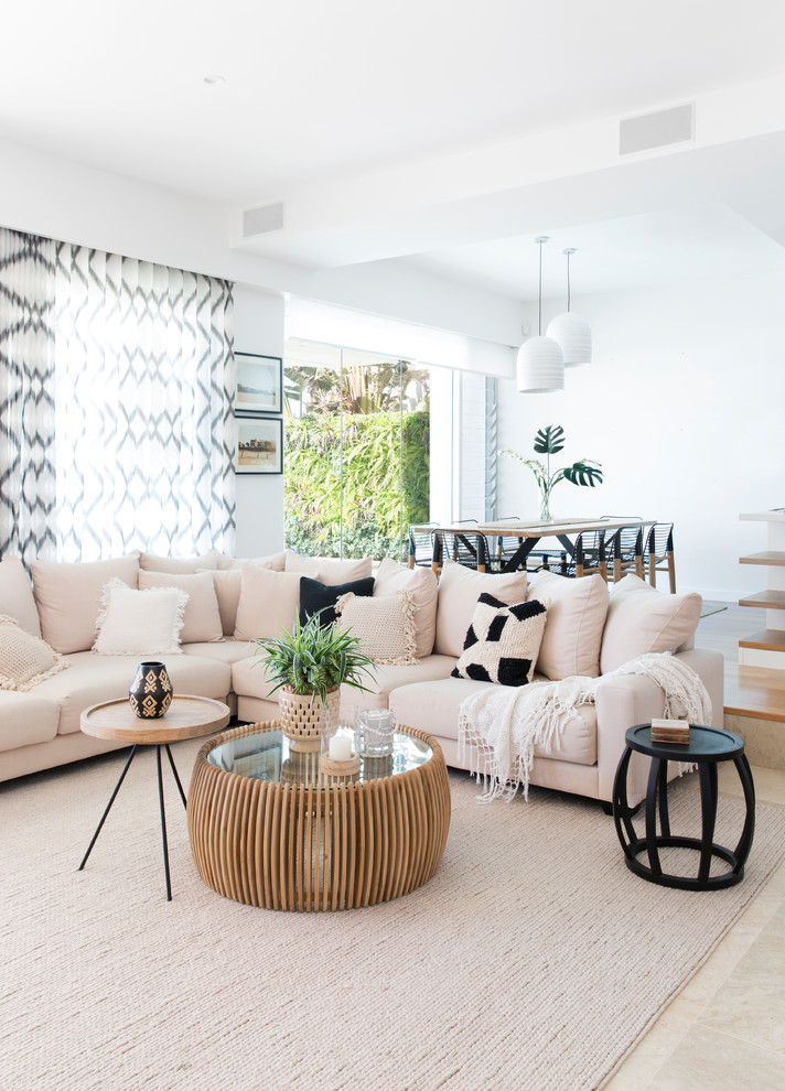 Foto di un grande soggiorno contemporaneo aperto con pareti bianche, pavimento in pietra calcarea, TV a parete e pavimento beige