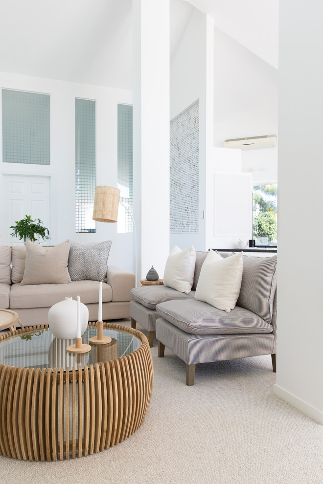 Источник вдохновения для домашнего уюта: большая открытая гостиная комната в современном стиле с белыми стенами, ковровым покрытием, телевизором на стене и серым полом