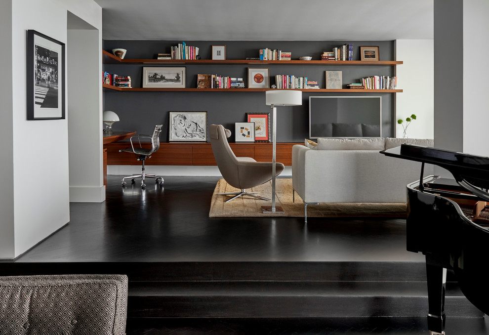 Diseño de biblioteca en casa abierta contemporánea con paredes grises, suelo de madera oscura y televisor independiente