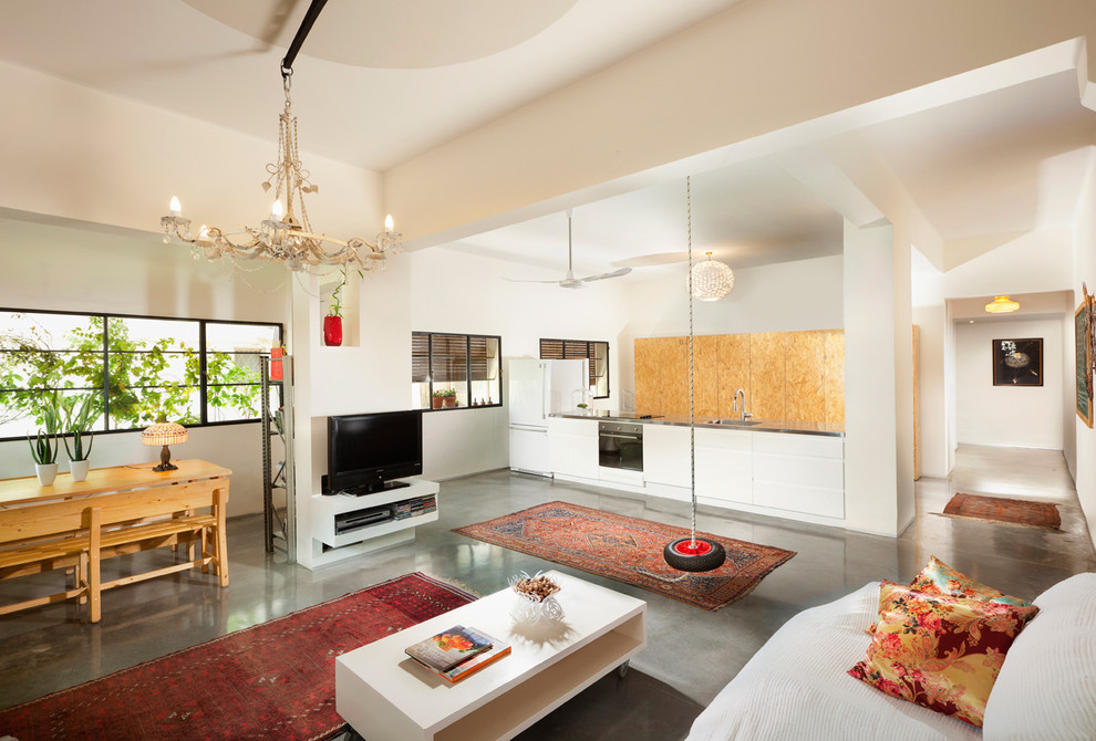 This is an example of an eclectic living room in Other with concrete flooring.