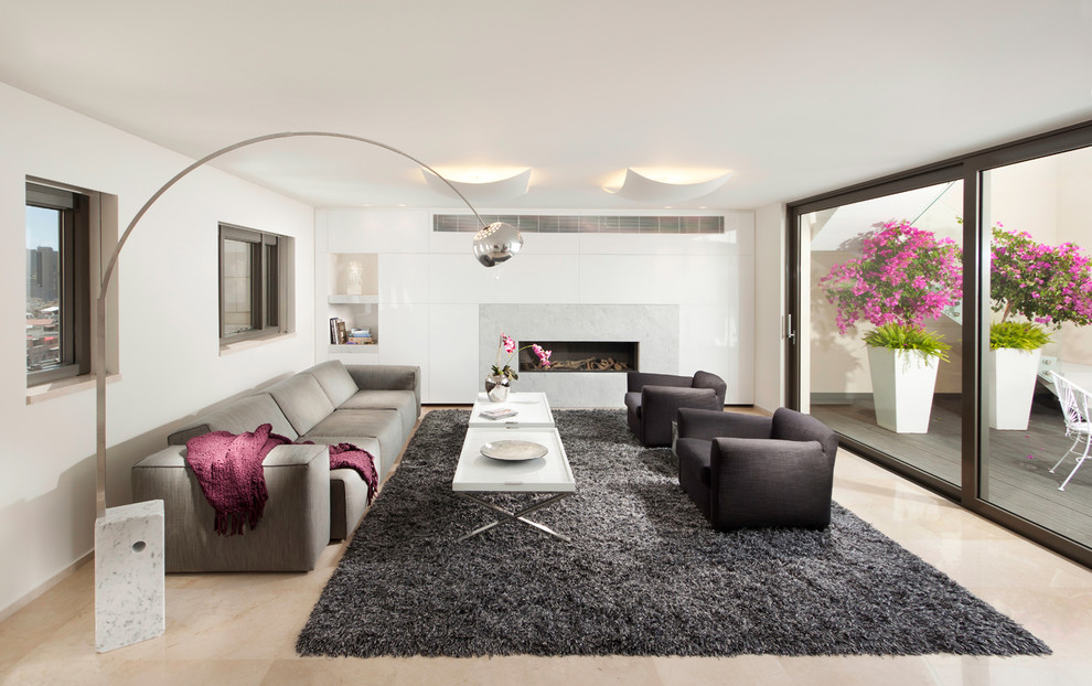 Idée de décoration pour un salon design avec un manteau de cheminée en pierre, un sol en marbre et éclairage.