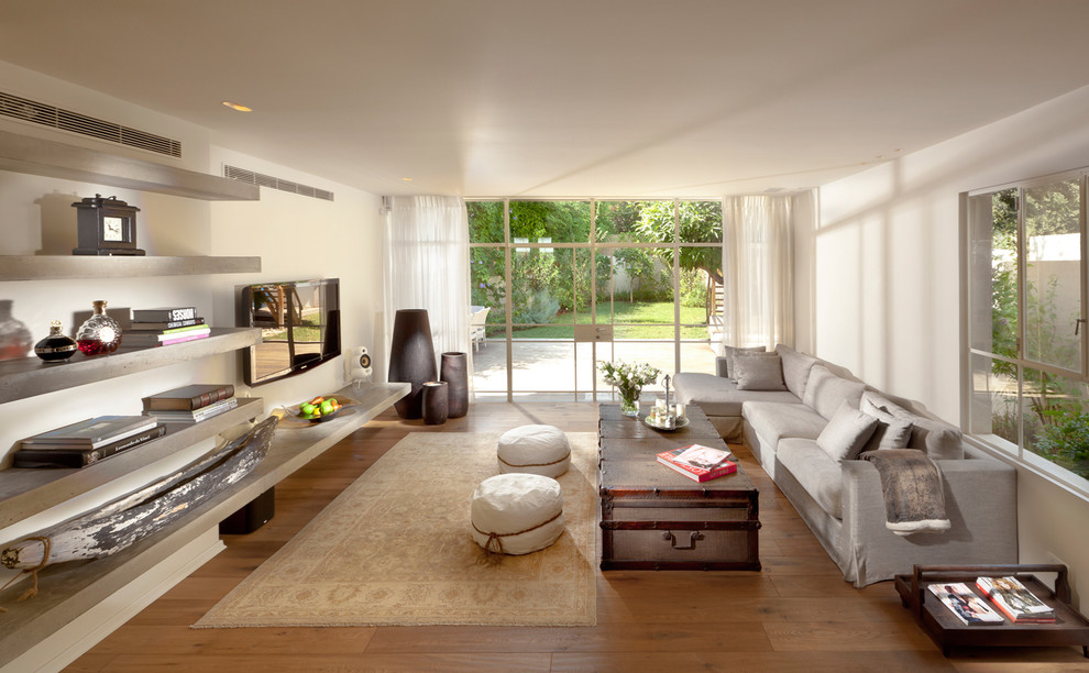 Источник вдохновения для домашнего уюта: гостиная комната в современном стиле с белыми стенами, телевизором на стене и красивыми шторами