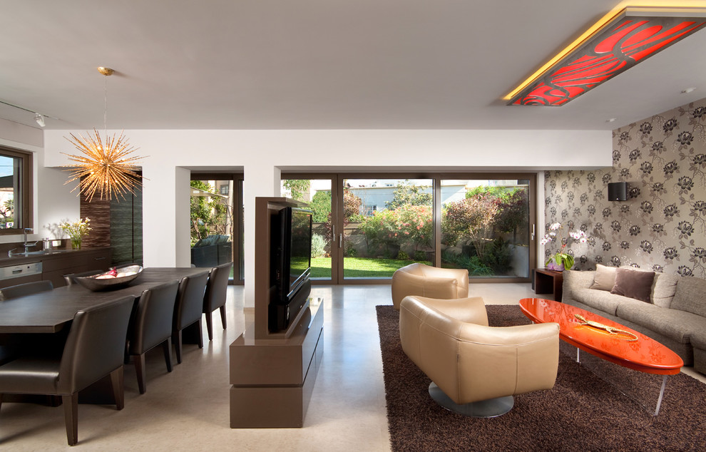 Источник вдохновения для домашнего уюта: открытая гостиная комната в современном стиле с телевизором на стене и ковром на полу