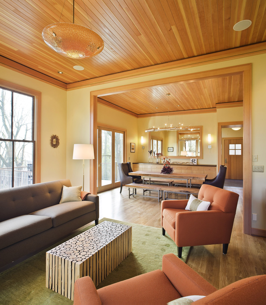 Ispirazione per un soggiorno design con pareti gialle e pavimento in legno massello medio