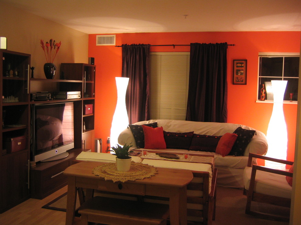 バンクーバーにあるエクレクティックスタイルのおしゃれなLDK (オレンジの壁、淡色無垢フローリング、コーナー設置型暖炉) の写真