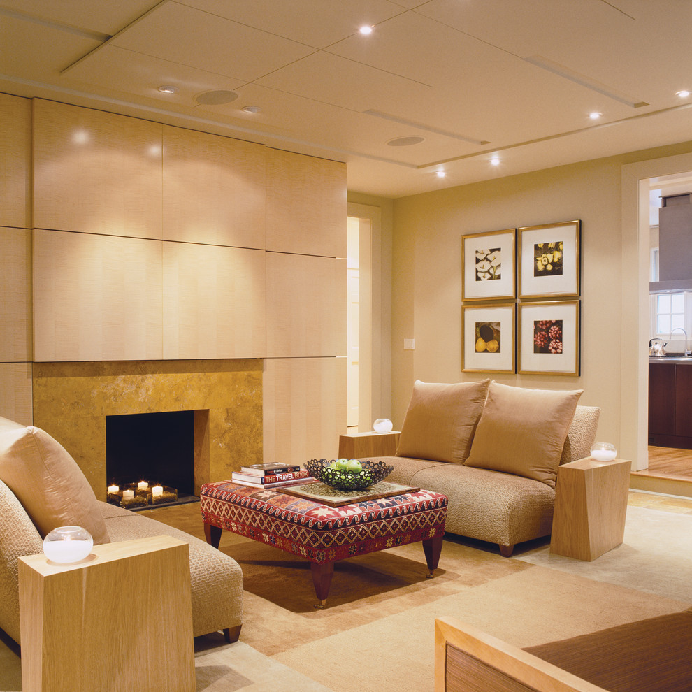 Esempio di un soggiorno design con pareti beige e camino classico
