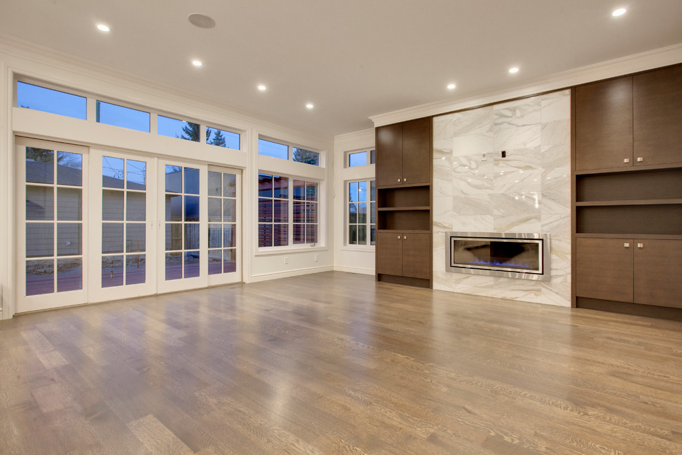 Photo of a large contemporary open plan living room in Calgary with a reading nook, white walls, medium hardwood flooring, a standard fireplace, a metal fireplace surround and a wall mounted tv.