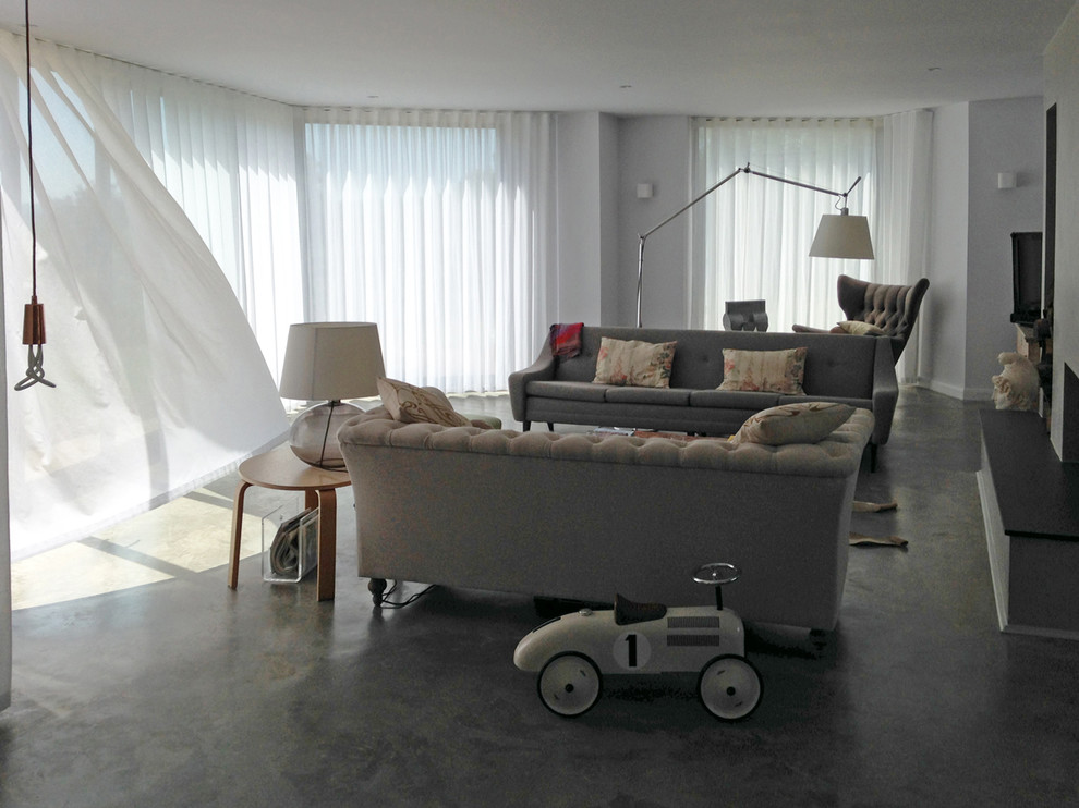 Esempio di un grande soggiorno minimal aperto con sala formale, pareti bianche, camino bifacciale, cornice del camino in intonaco e TV autoportante