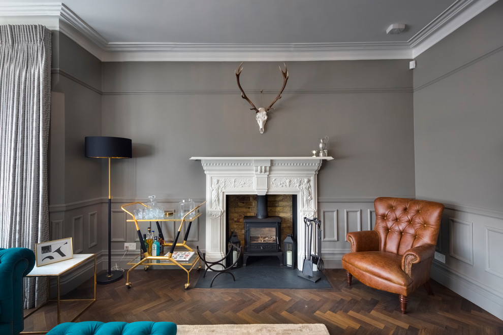 ロンドンにあるお手頃価格の中くらいなトランジショナルスタイルのおしゃれな独立型リビング (茶色い壁、濃色無垢フローリング、テレビなし、茶色い床、薪ストーブ) の写真