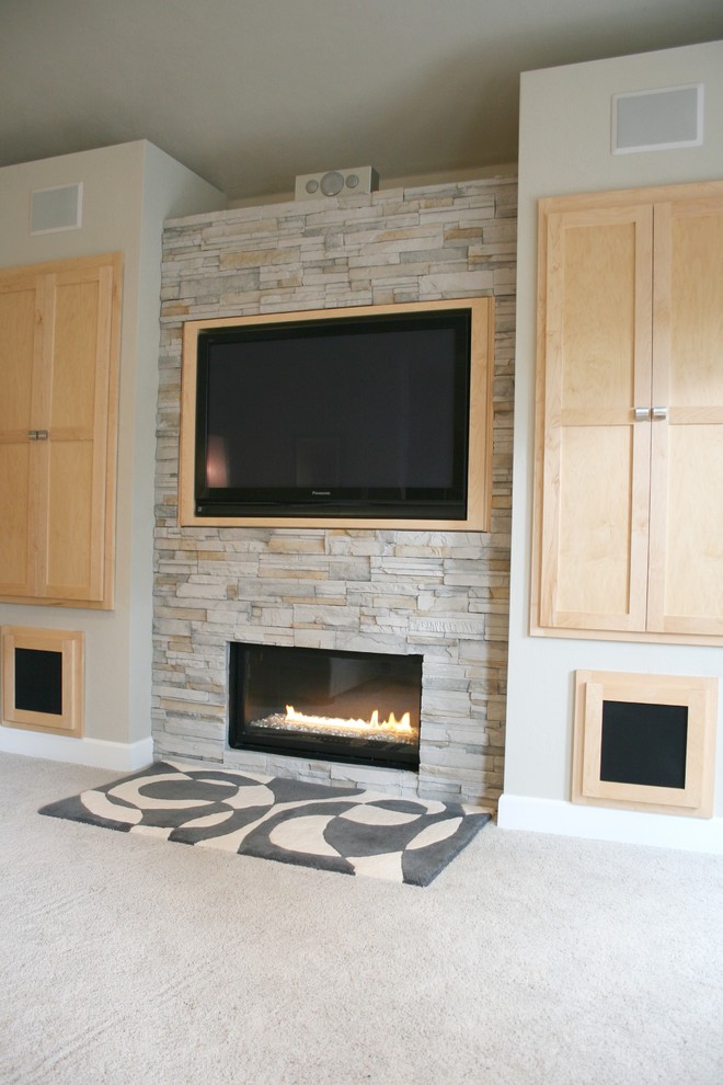 Foto de salón abierto minimalista de tamaño medio con paredes grises, chimenea lineal, marco de chimenea de piedra y pared multimedia