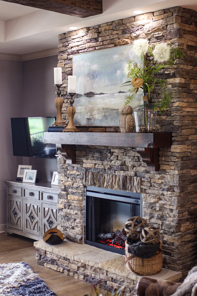 Inspiration for a large rustic open plan living room in Other with grey walls, medium hardwood flooring, a standard fireplace, a stone fireplace surround, a wall mounted tv and brown floors.