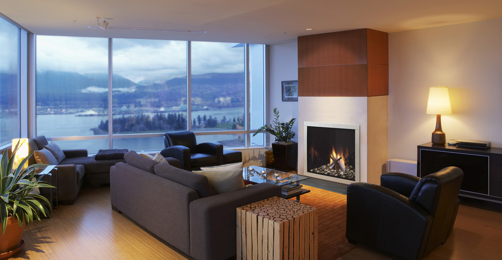 Exemple d'un grand salon moderne fermé avec un mur blanc, un sol en bois brun, une cheminée standard et un manteau de cheminée en métal.