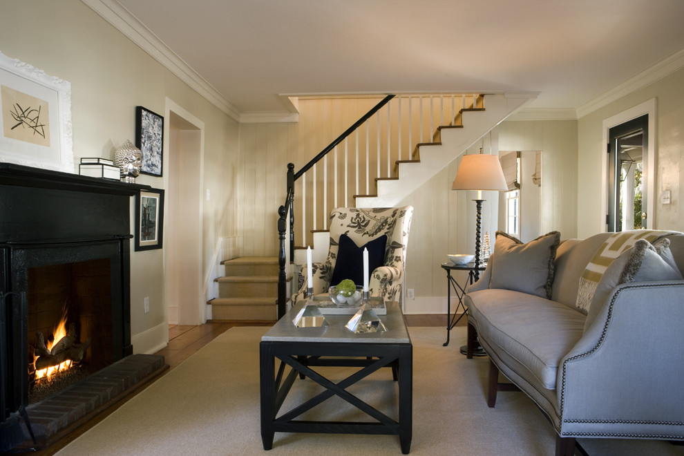 Cette photo montre un salon chic de taille moyenne et fermé avec une cheminée standard, un sol en bois brun et un escalier.
