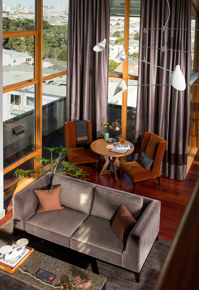 Идея дизайна: большая открытая гостиная комната в современном стиле с серыми стенами, темным паркетным полом и коричневым полом без камина