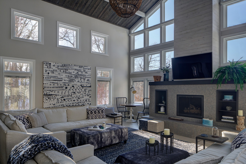 This is an example of a large traditional mezzanine living room in Chicago with beige walls, light hardwood flooring, a standard fireplace and a wall mounted tv.