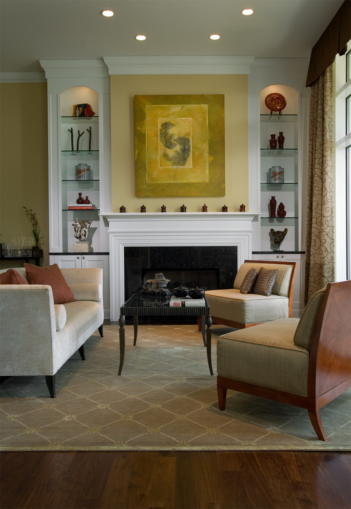 Idee per un soggiorno design con pareti gialle, parquet scuro e camino classico