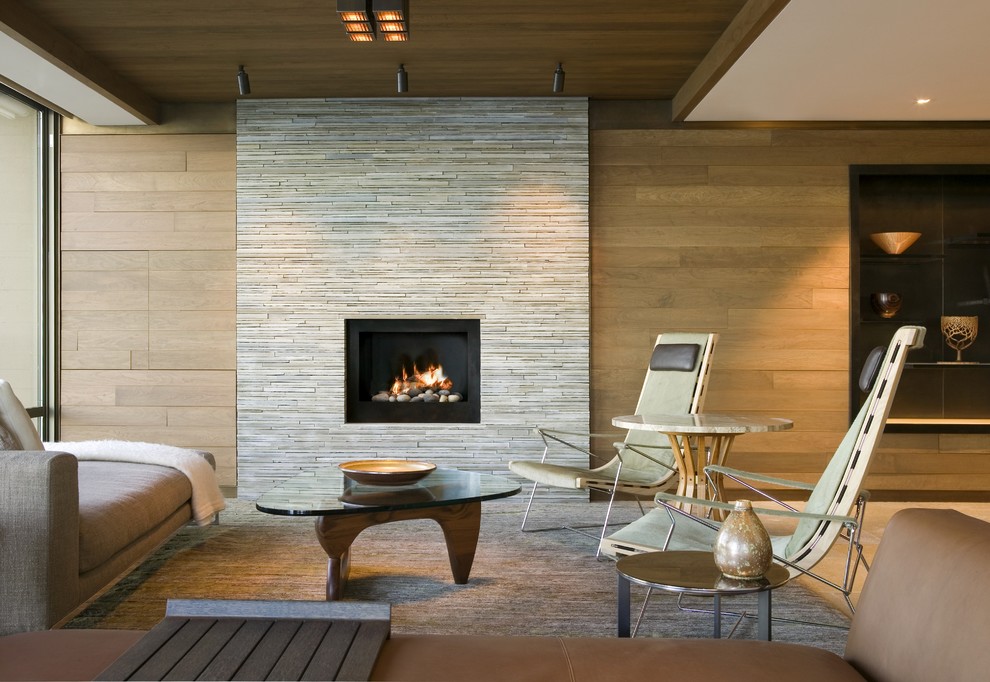 シアトルにあるラグジュアリーな中くらいなコンテンポラリースタイルのおしゃれなリビング (茶色い壁、標準型暖炉、石材の暖炉まわり、テレビなし、茶色い床) の写真