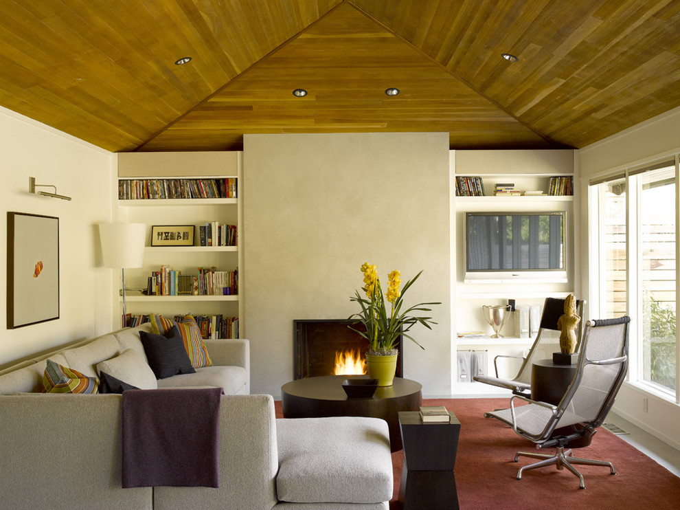Mittelgroßes, Repräsentatives, Fernseherloses Modernes Wohnzimmer mit beiger Wandfarbe, Kamin, Kaminumrandung aus Beton und grauem Boden in Seattle