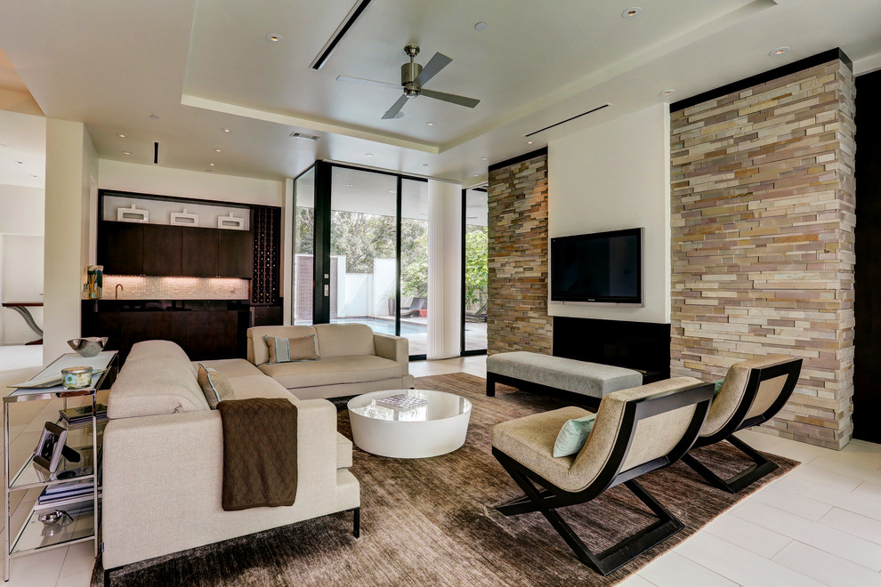 Großes, Offenes Modernes Wohnzimmer mit weißer Wandfarbe, Porzellan-Bodenfliesen, Kamin, Kaminumrandung aus Stein und TV-Wand in Houston