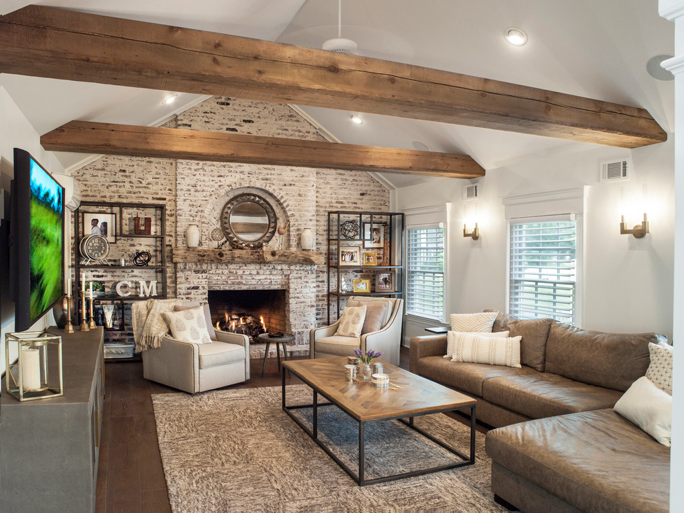 Design ideas for a rural living room in New York with white walls, dark hardwood flooring, a standard fireplace, a brick fireplace surround and brown floors.