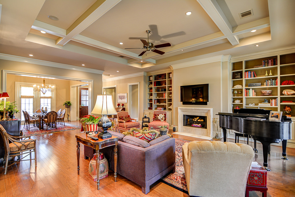 Example of a classic formal and open concept medium tone wood floor living room design in Austin with beige walls, a standard fireplace, a concrete fireplace and a wall-mounted tv