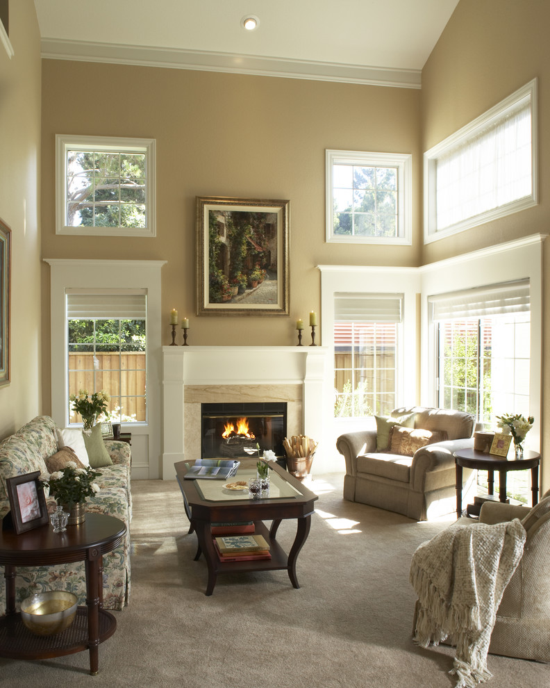Cette image montre un grand salon traditionnel avec un mur beige et une cheminée standard.
