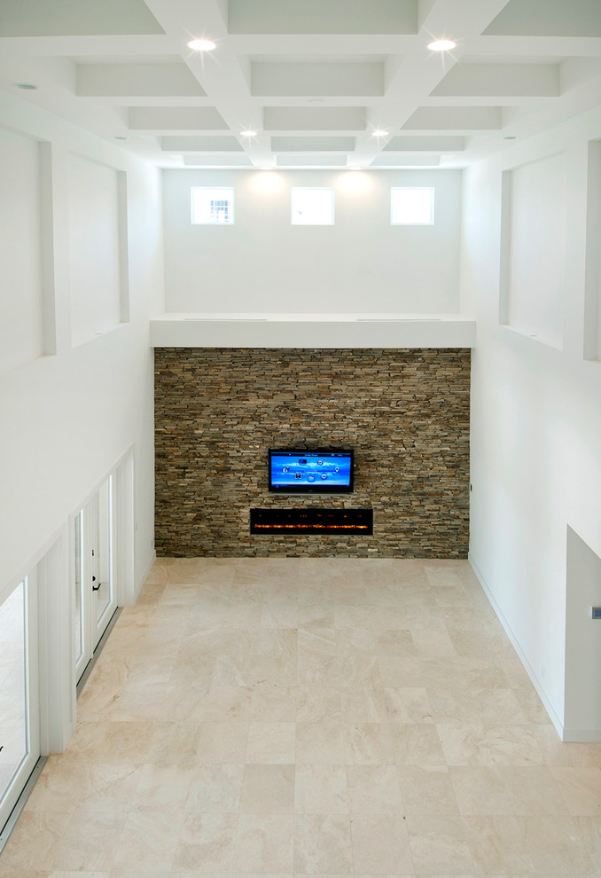 Modern inredning av ett mycket stort allrum med öppen planlösning, med vita väggar, travertin golv, en bred öppen spis, en spiselkrans i sten och en inbyggd mediavägg