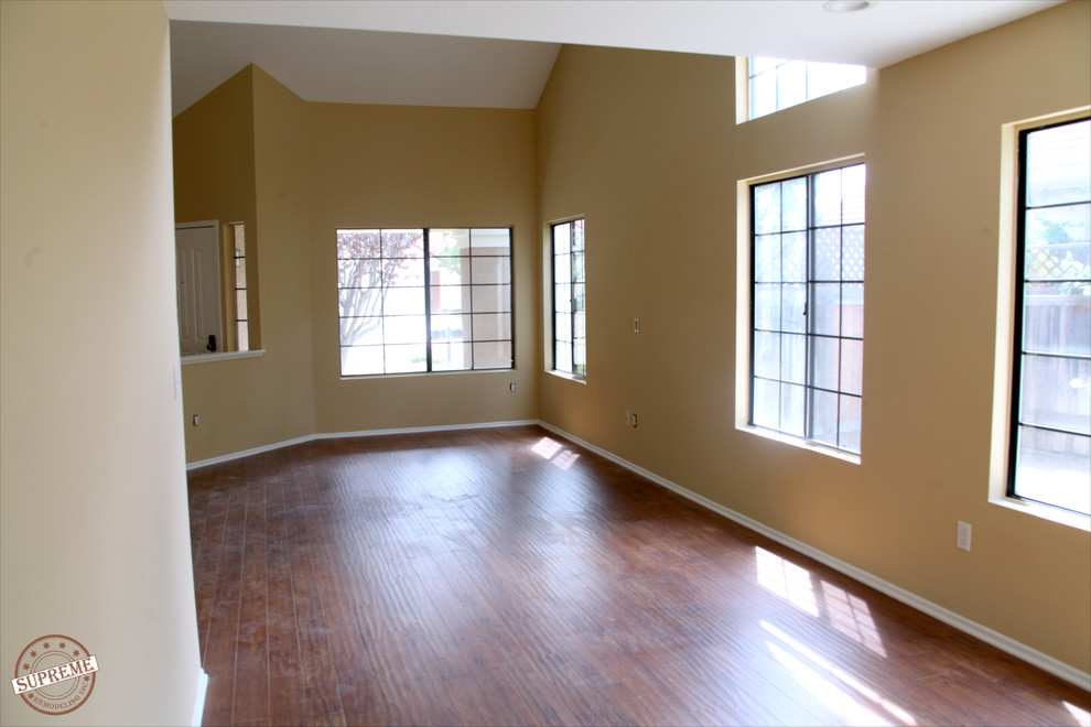 Foto di un grande soggiorno minimal stile loft con pareti gialle e pavimento in legno massello medio