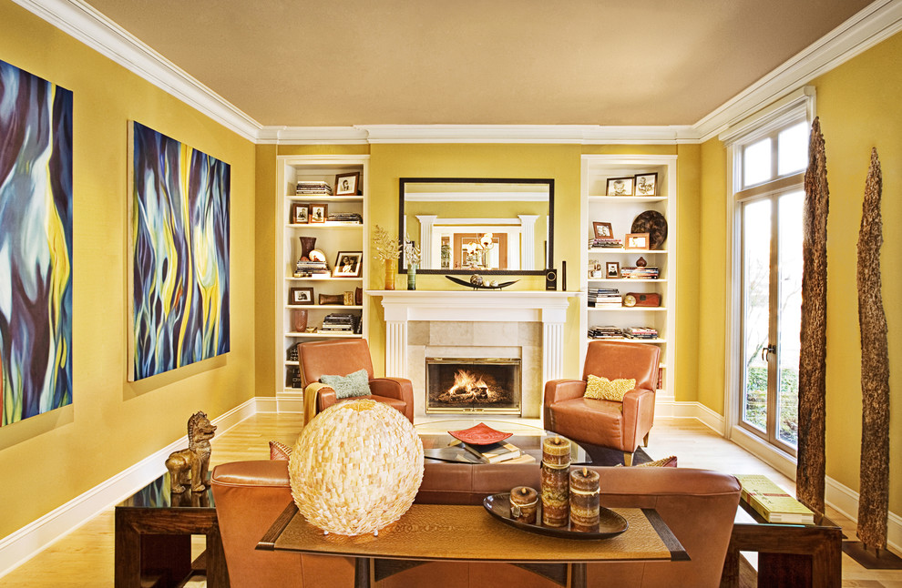 Стильный дизайн: изолированная гостиная комната в классическом стиле с желтыми стенами и стандартным камином без телевизора - последний тренд