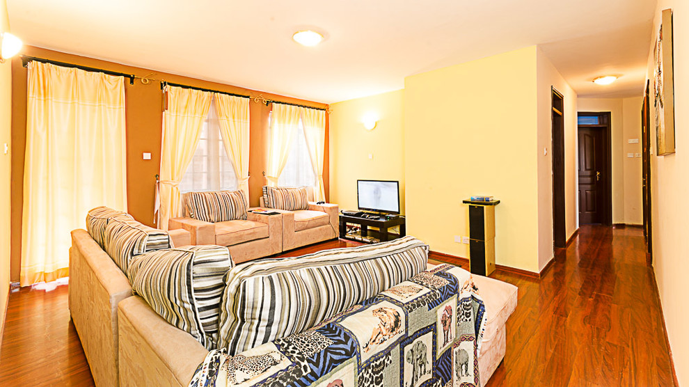 Exempel på ett litet modernt separat vardagsrum, med en hemmabar, beige väggar, ljust trägolv, en fristående TV och brunt golv