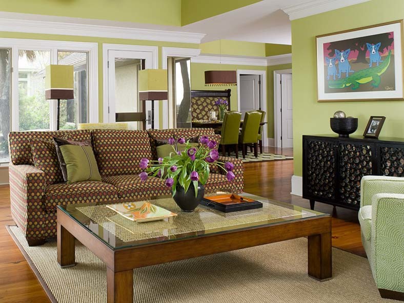 Idée de décoration pour un salon tradition ouvert avec un mur vert et un sol en bois brun.