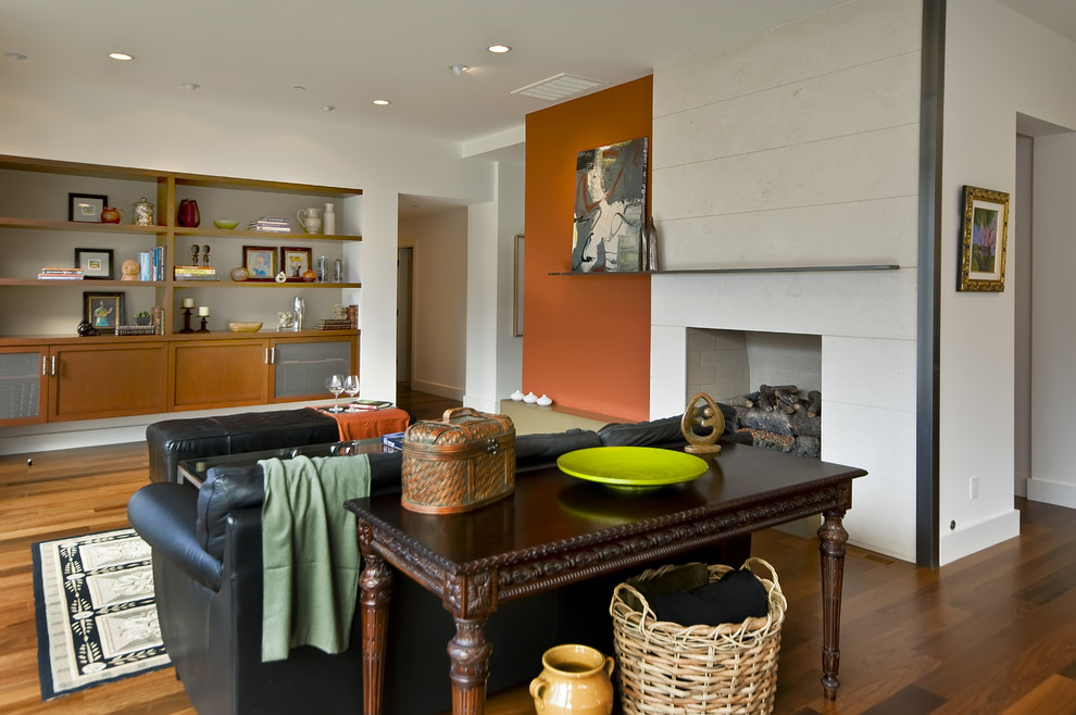Immagine di un soggiorno minimal di medie dimensioni e aperto con sala formale, pavimento in legno massello medio, camino classico e cornice del camino in pietra