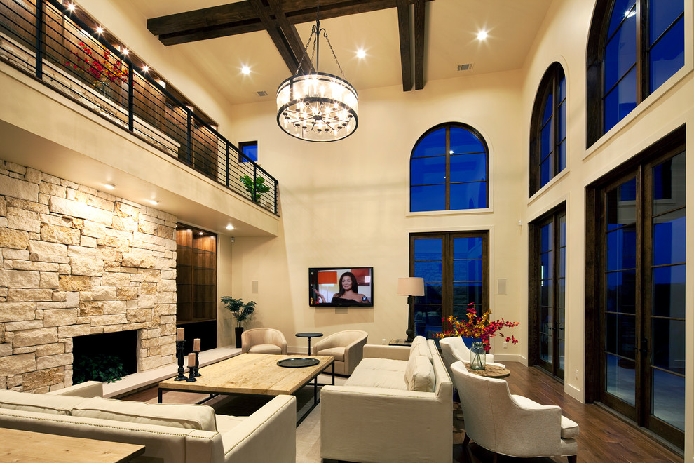 Bild på ett medelhavsstil vardagsrum, med beige väggar, en standard öppen spis och en väggmonterad TV