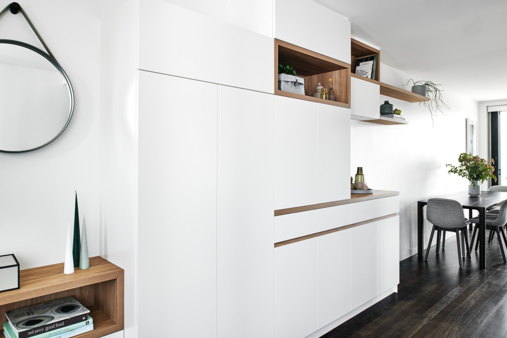 Idéer för stora minimalistiska separata vardagsrum, med vita väggar, mörkt trägolv, en inbyggd mediavägg och brunt golv