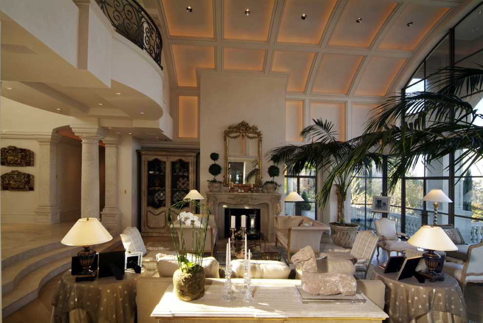 Réalisation d'un grand salon méditerranéen ouvert avec une salle de réception, un mur blanc, parquet clair, une cheminée standard et un manteau de cheminée en plâtre.