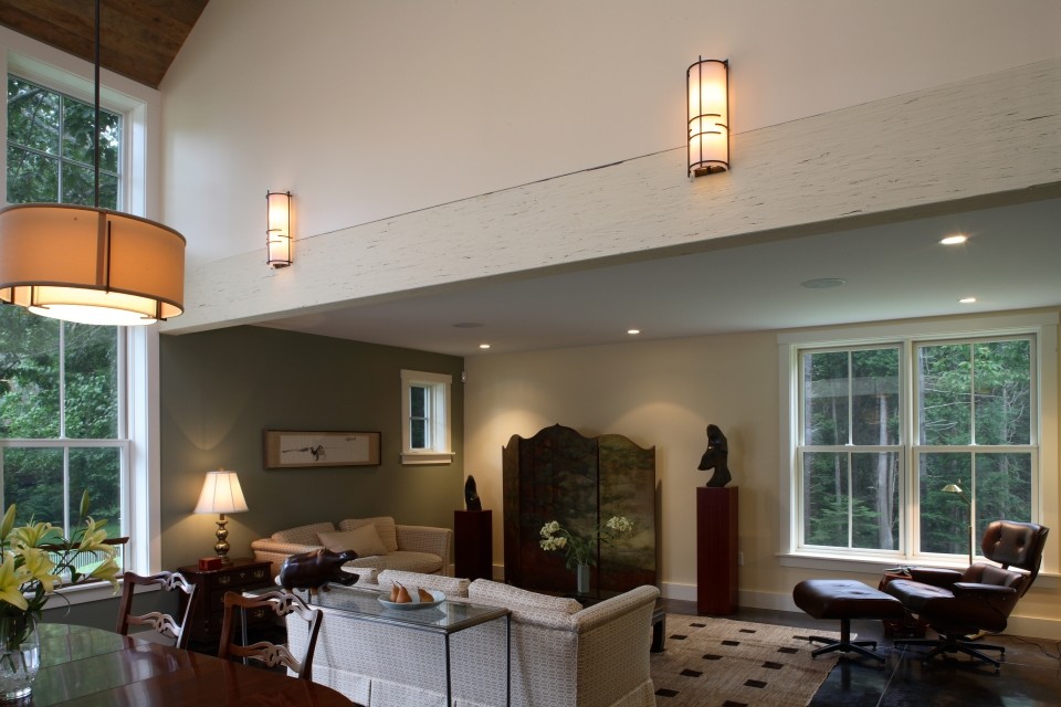 Aménagement d'un salon classique de taille moyenne et ouvert avec un mur vert, sol en béton ciré, une cheminée standard, un manteau de cheminée en pierre et un téléviseur dissimulé.