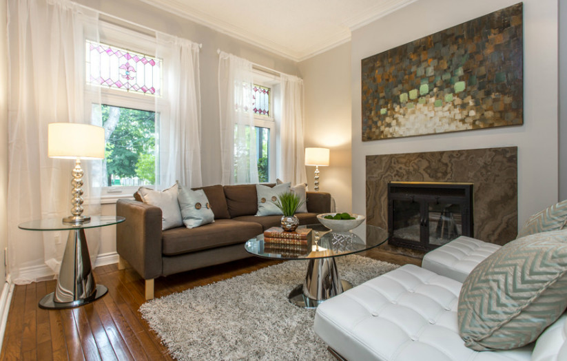 Mittelgroßes, Repräsentatives, Offenes, Fernseherloses Modernes Wohnzimmer mit beiger Wandfarbe, braunem Holzboden, Kamin und gefliester Kaminumrandung in Toronto