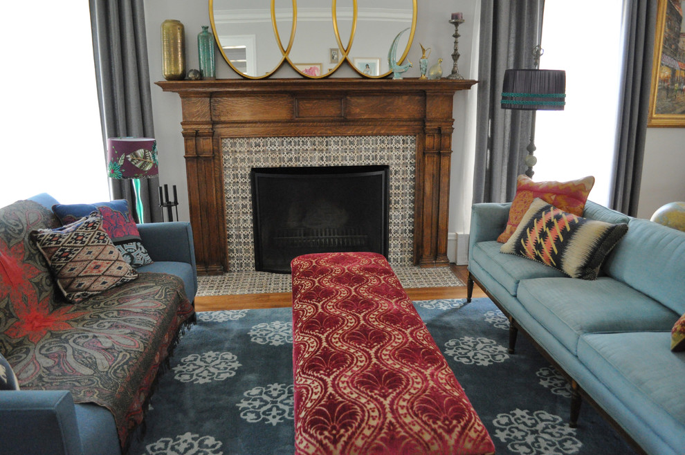 На фото: гостиная комната в стиле фьюжн с фасадом камина из плитки и ковром на полу с