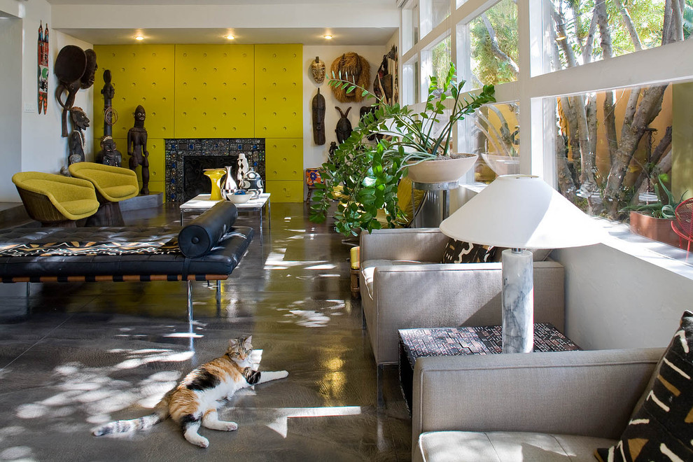 Idéer för ett eklektiskt vardagsrum, med gula väggar, betonggolv och en standard öppen spis