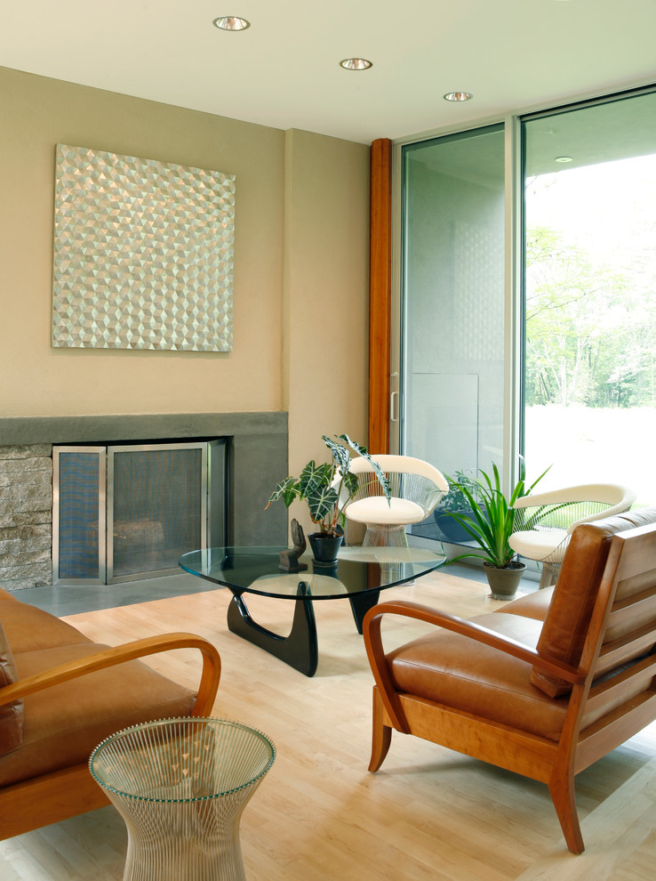 Diseño de salón abierto minimalista de tamaño medio sin televisor con paredes beige, suelo de madera clara, todas las chimeneas, marco de chimenea de piedra y suelo marrón