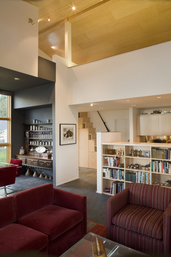 Cette photo montre un salon éclectique avec une bibliothèque ou un coin lecture, un sol en ardoise et un escalier.