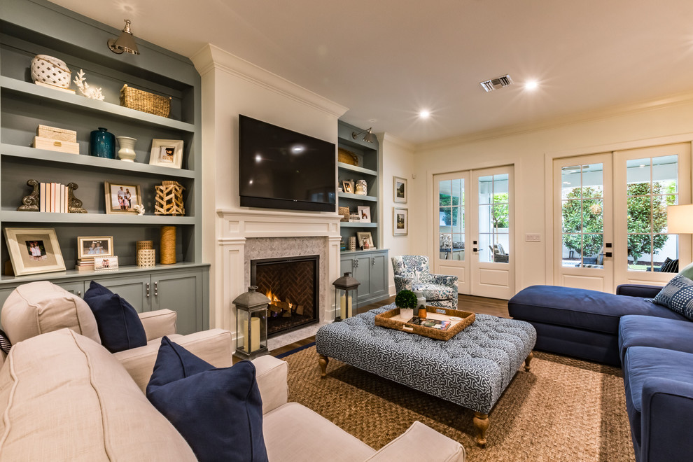 Klassisches Wohnzimmer mit TV-Wand, weißer Wandfarbe, braunem Holzboden, Kamin, Kaminumrandung aus Stein und braunem Boden in Orlando
