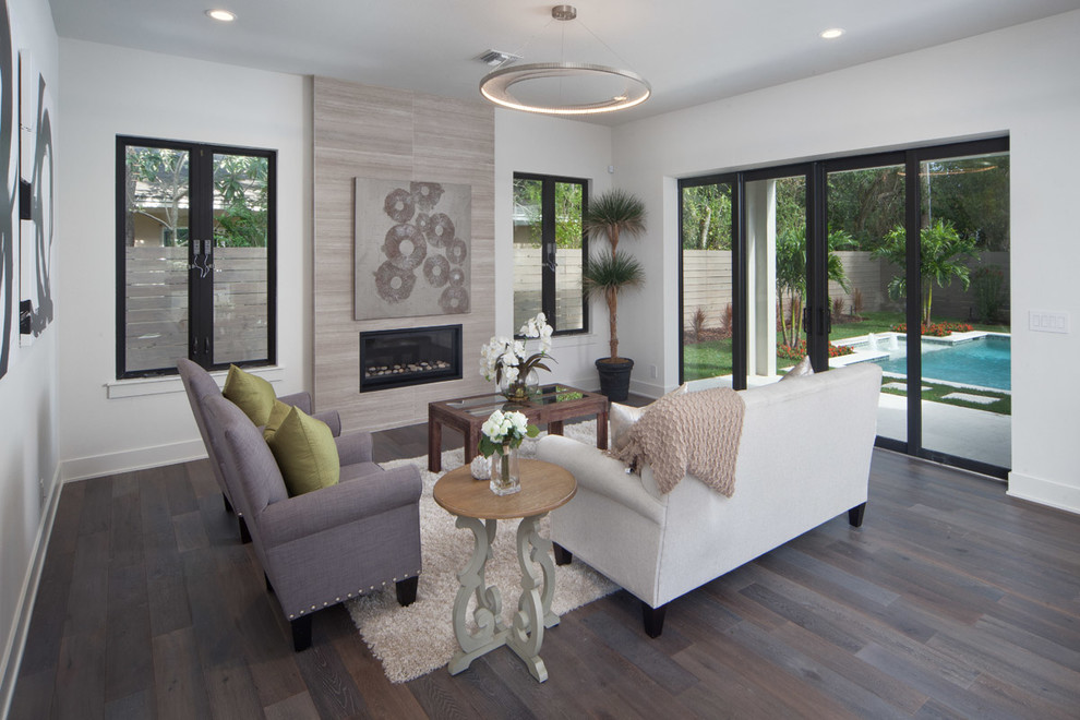 Large minimalist open concept dark wood floor living room photo in Orlando with white walls, a standard fireplace, a tile fireplace and a wall-mounted tv