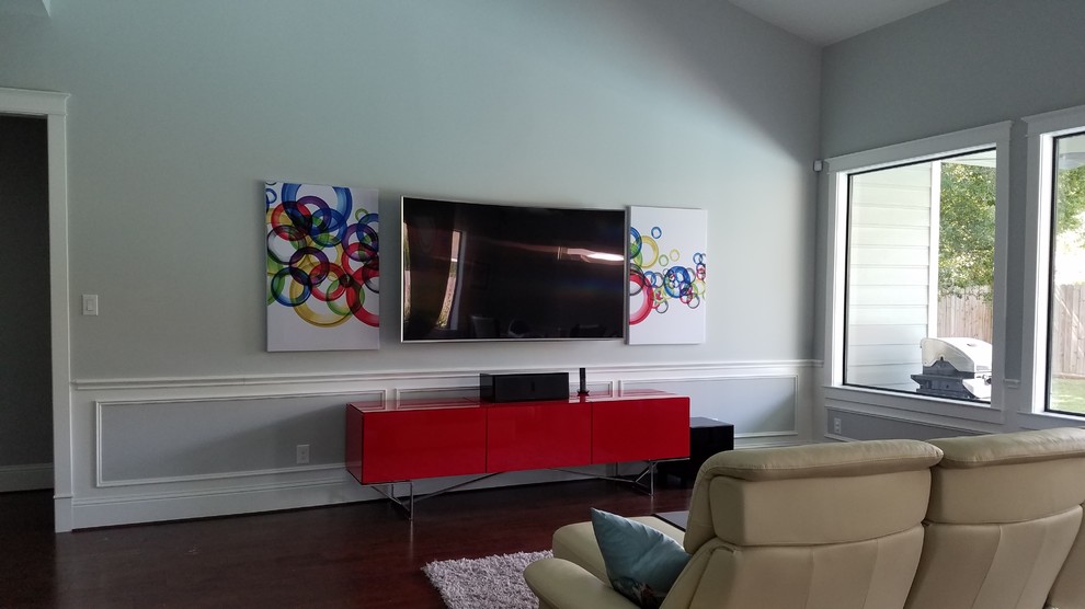 Mittelgroßes, Offenes Modernes Wohnzimmer mit grauer Wandfarbe, dunklem Holzboden, TV-Wand und braunem Boden in Houston